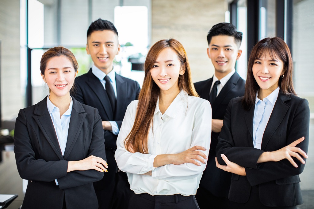 confident asian business team stands in office